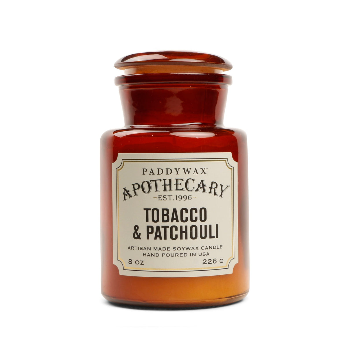 Αρωματικό κερί σόγιας Paddywax Apothecary Tobacco & Patchouli 226g σε κεχριμπαρένιο γυάλινο βάζο φαρμακείου.